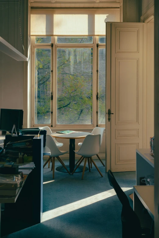 the empty room has white chairs near the windows