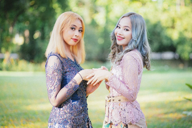 two young ladies dressed in beautiful clothing posing for a picture