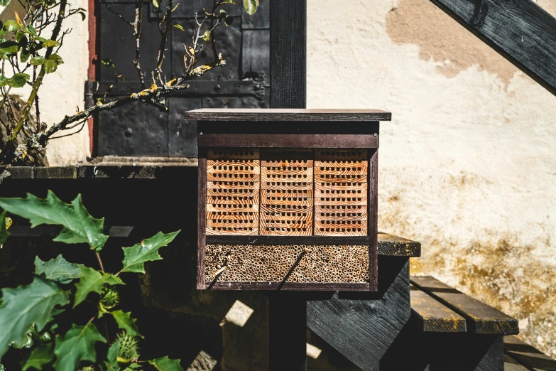 a wooden bird box next to a white wall