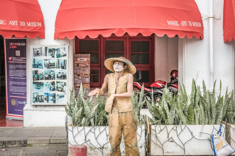 a statue sitting outside a building with lots of plants