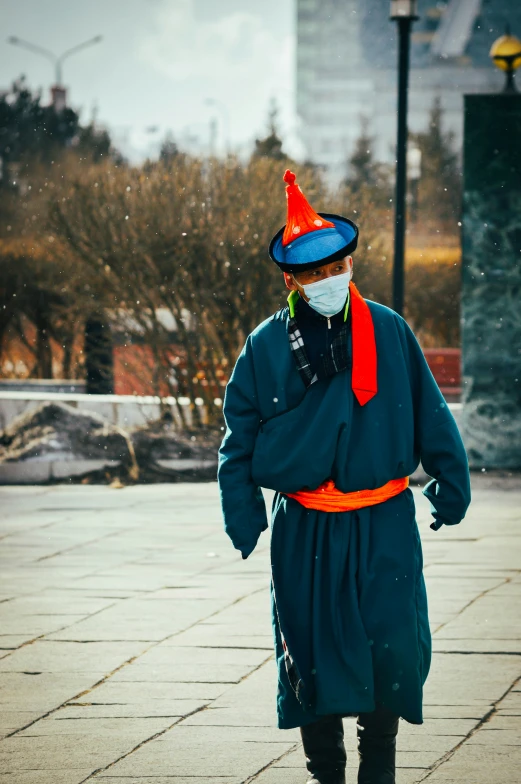 a person standing on the ground wearing a coat and mask