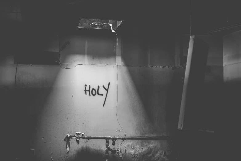 black and white po of a light inside a room with graffiti on the walls
