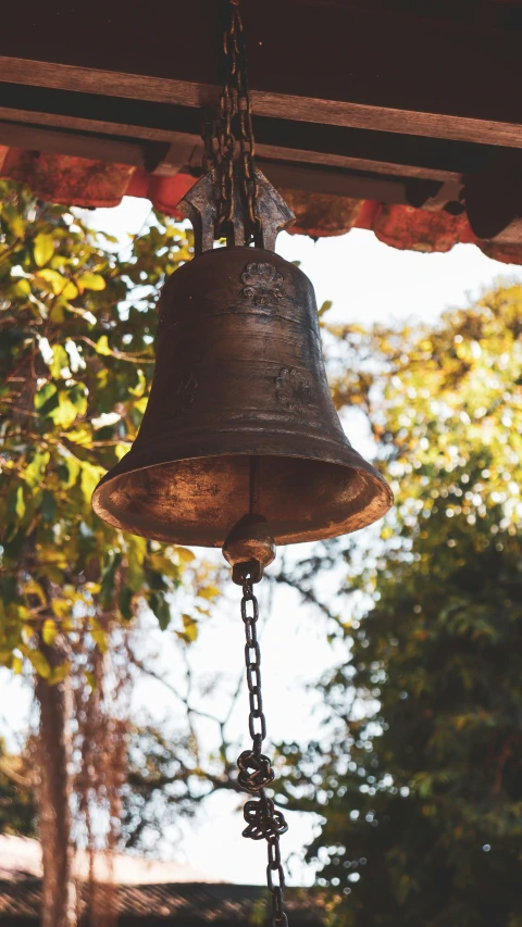 an old bell hangs from a chains and chain