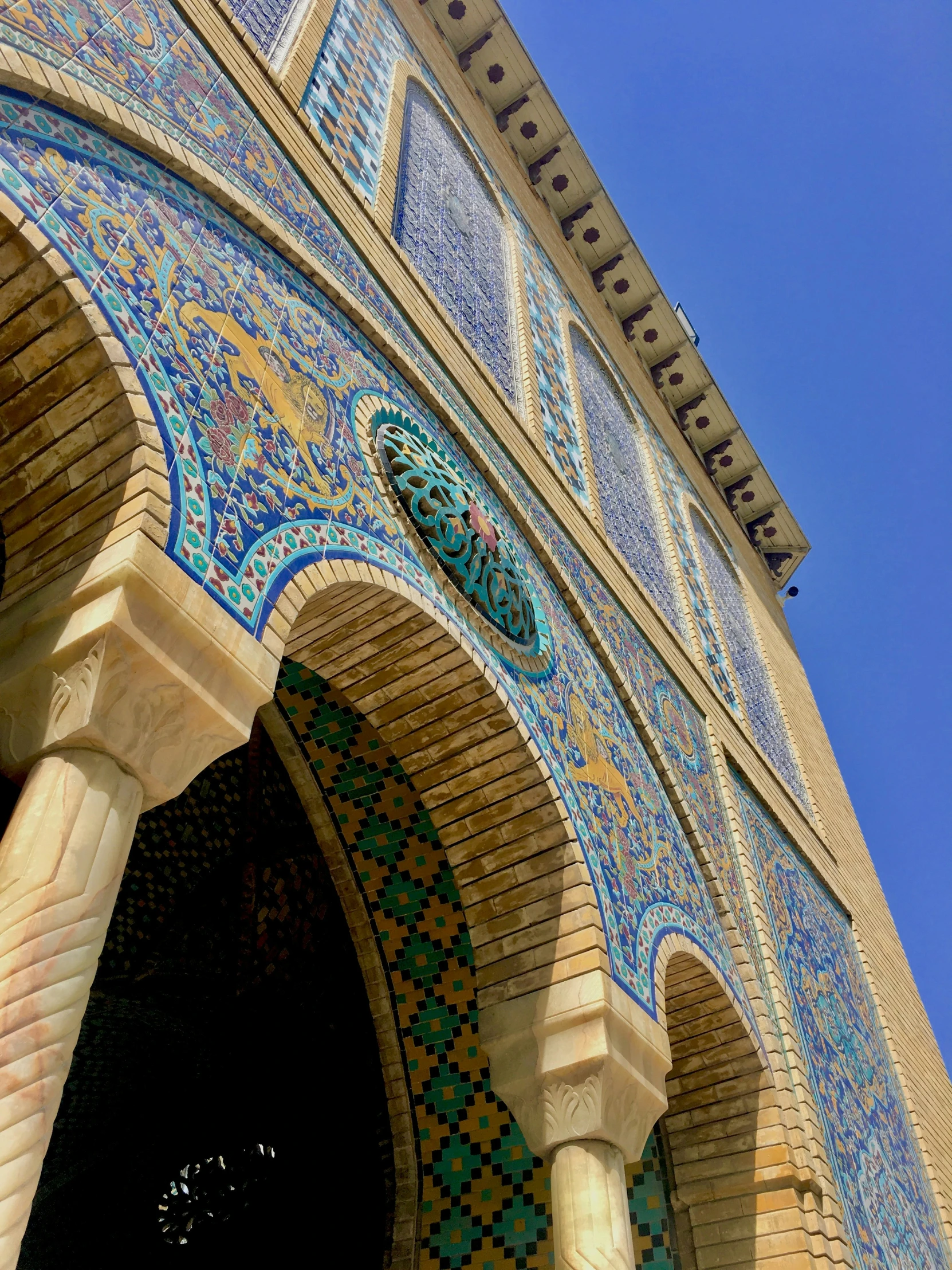 the arches and windows of a building with a blue sky in the background