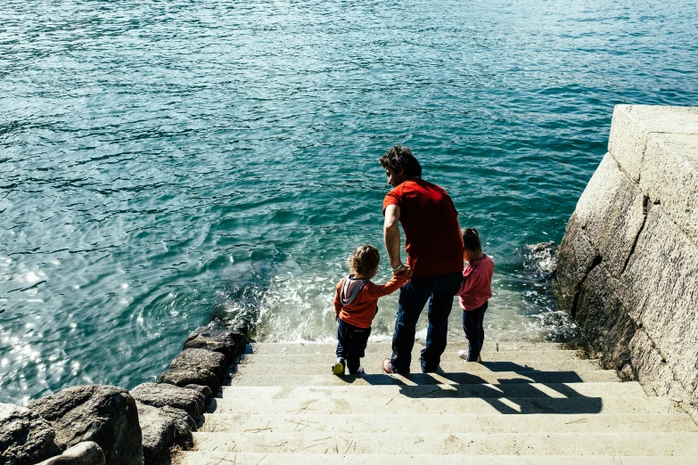 a man and two children walk up some stairs