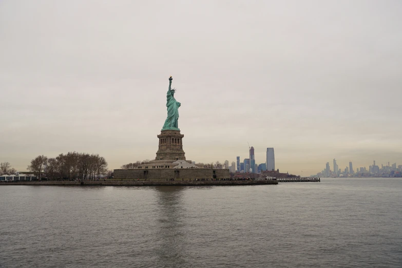 the statue of liberty is in the middle of a body of water