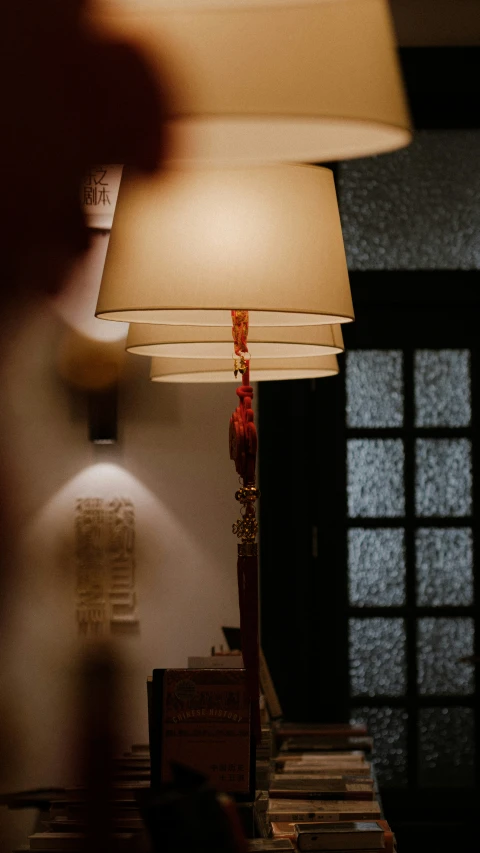 a lamp sitting on a table next to a bookshelf