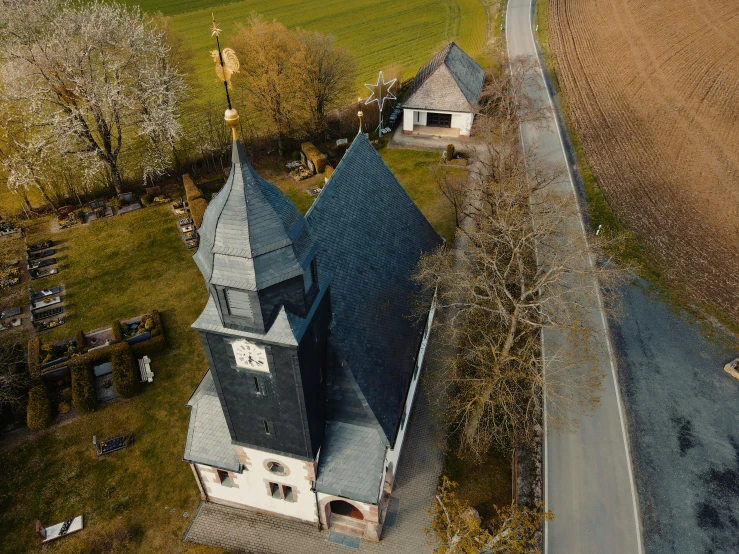 an aerial s of a small church in the middle of a field