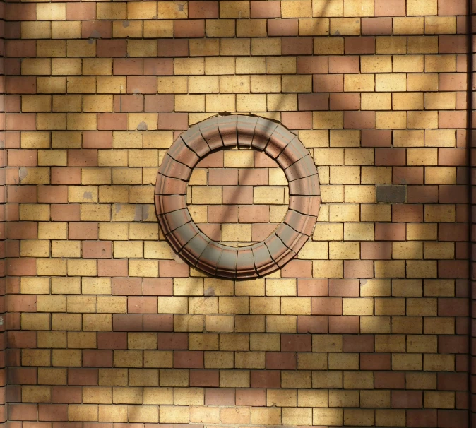 the shadow of a brick wall over the ring on it