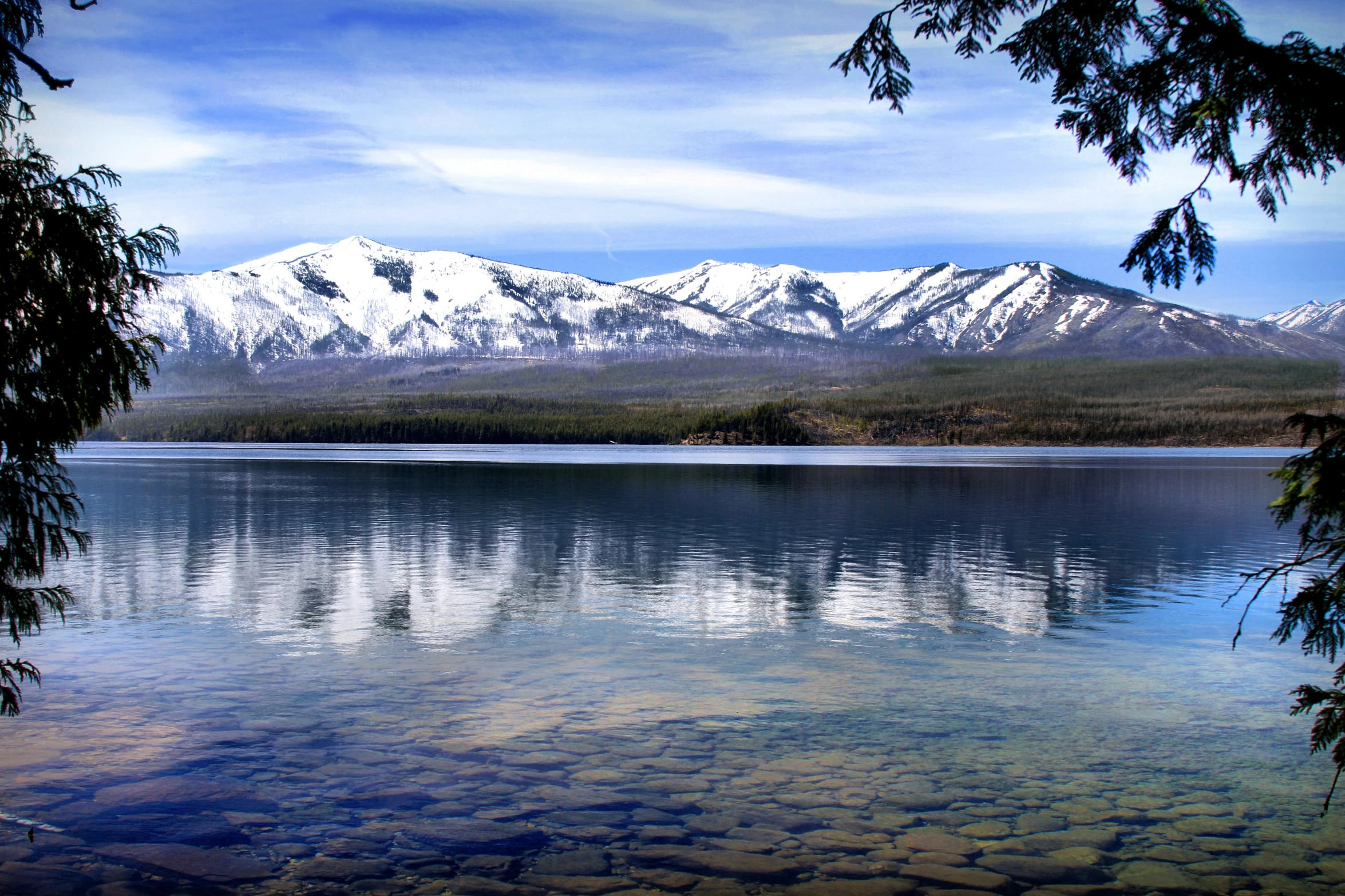 a lake surrounded by snow capped mountains