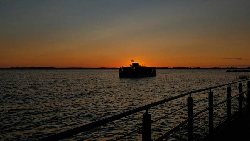 a boat on water at sunset near dock