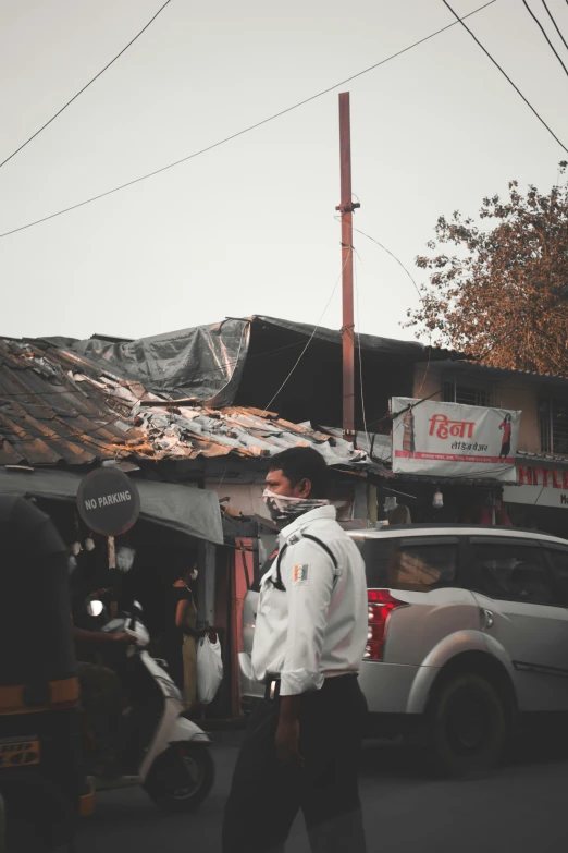 a man with a backpack and jacket walking down a street