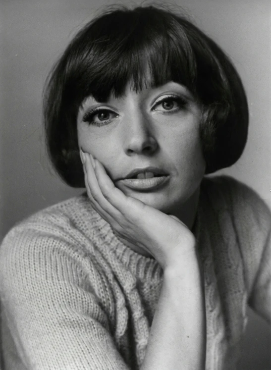 a woman sitting down with her hand on her face