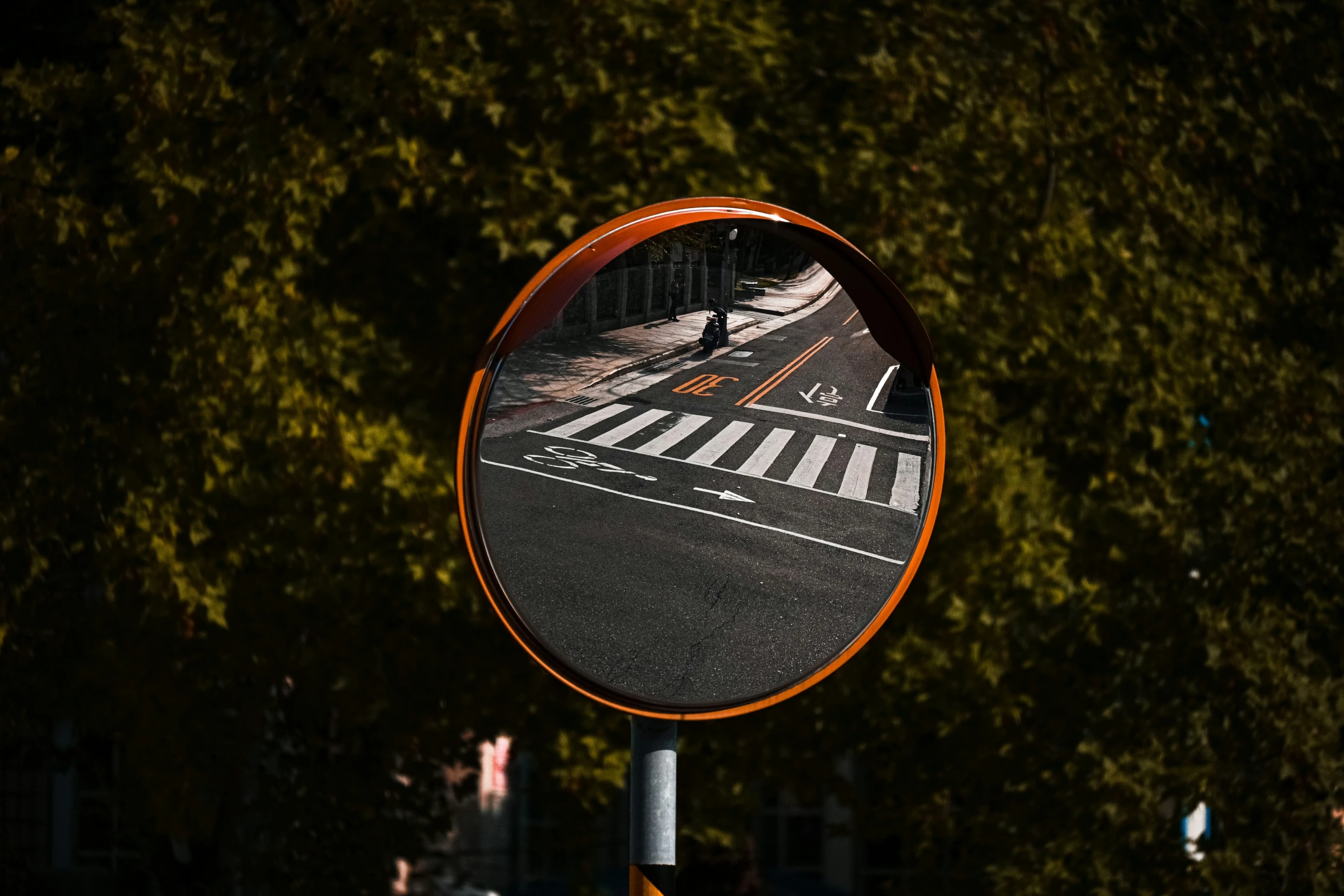 a circular mirror reflecting street lights in the background