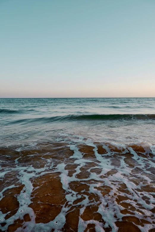 the water is wavy and foamy on the shore