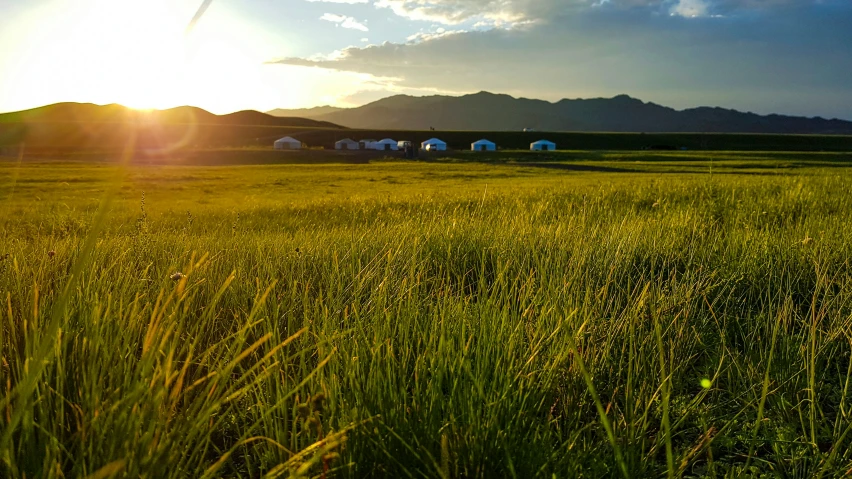 the sun is setting over an open field