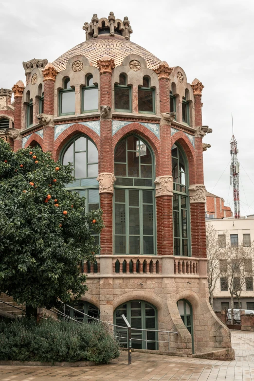 a tall brick building with many windows next to bushes