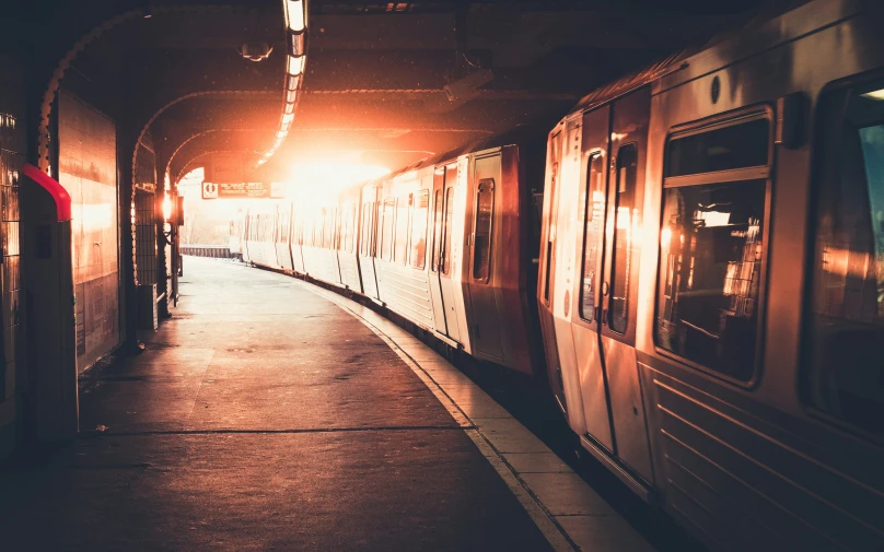 a red subway train traveling through a train station