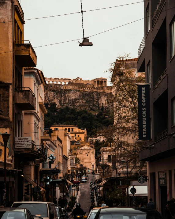 a cable car riding along a street filled with parked cars