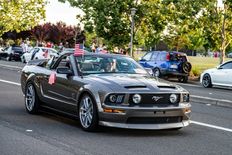 an mustang in an american car parade with the hood down