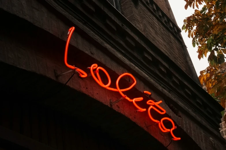 a neon sign that reads love hanging on a wall