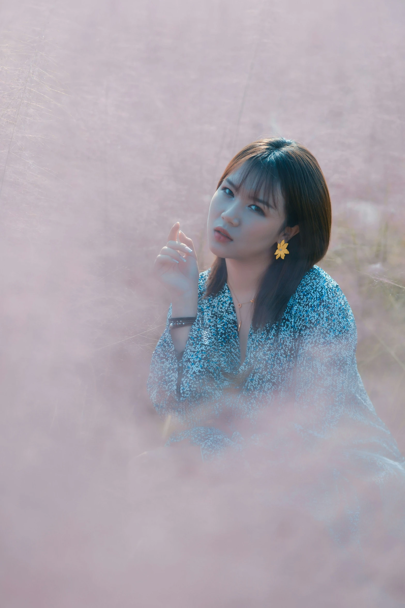 an asian woman in the middle of a smoke filled field