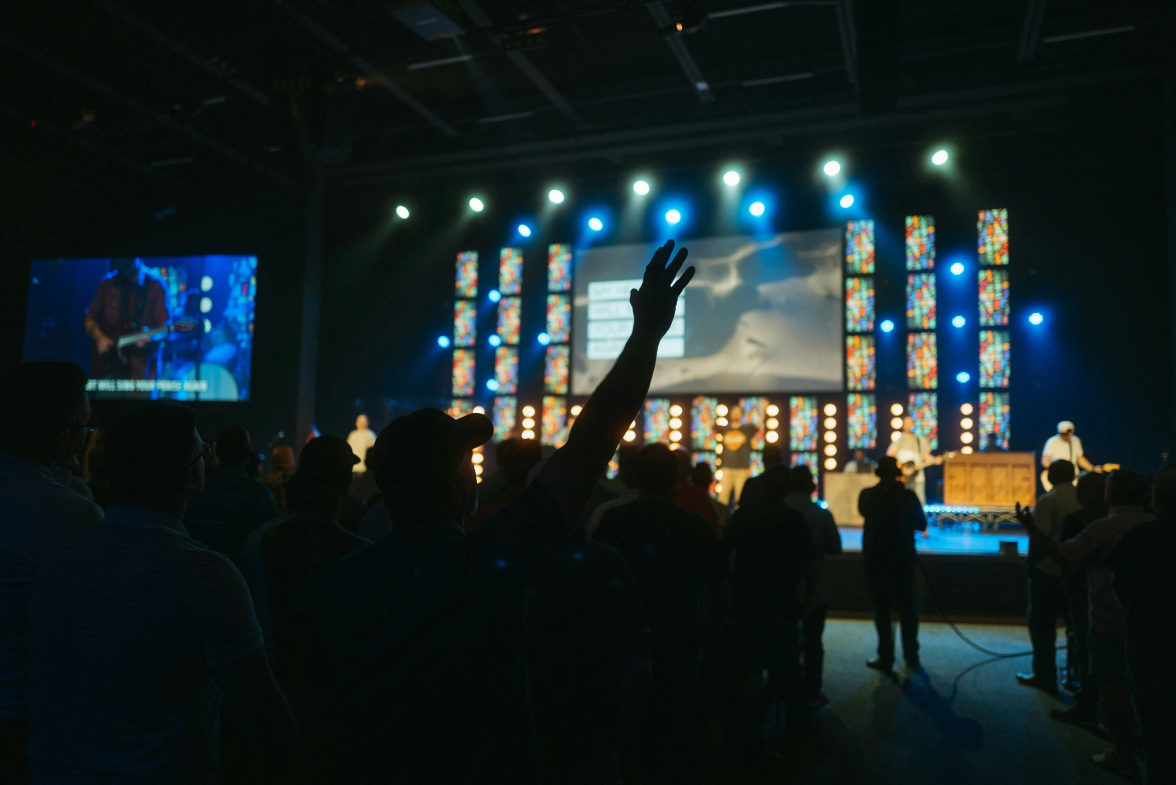 people on stage taking pictures of a person raising their hands