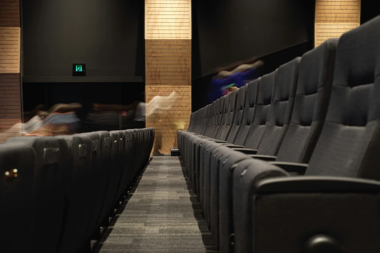 people sitting in an auditorium or theatre in the dark