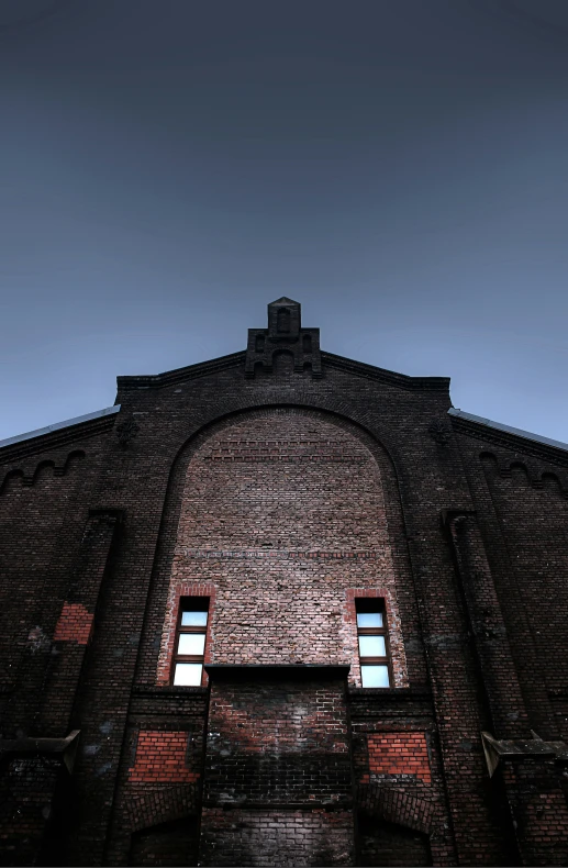 an old building with four windows is looking upward