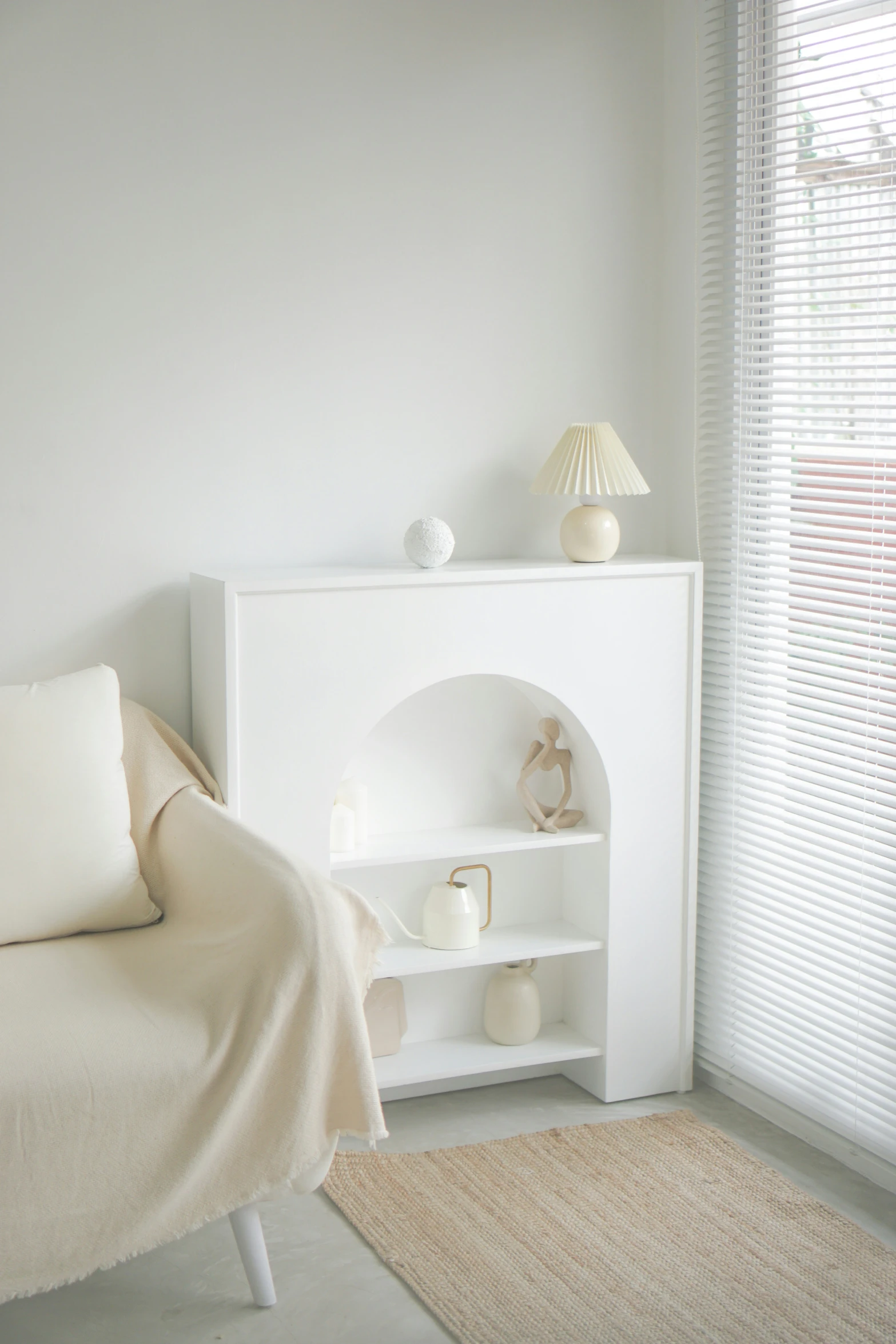 an arch shelf is in the corner of a white room