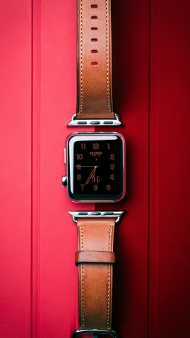 apple watch on leather band on red background