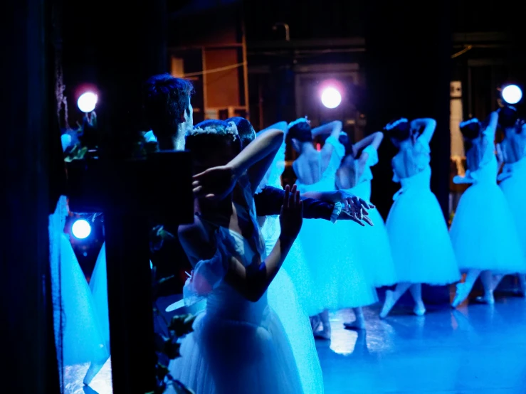 a group of women dressed in dress standing around in the dark