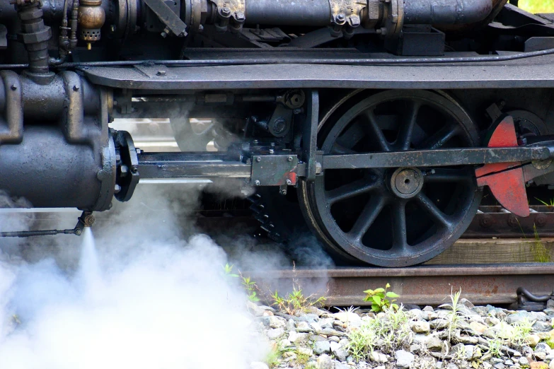 steam rises as the train engine wheels break apart