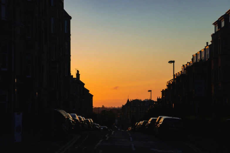 the view of a city street at sunset