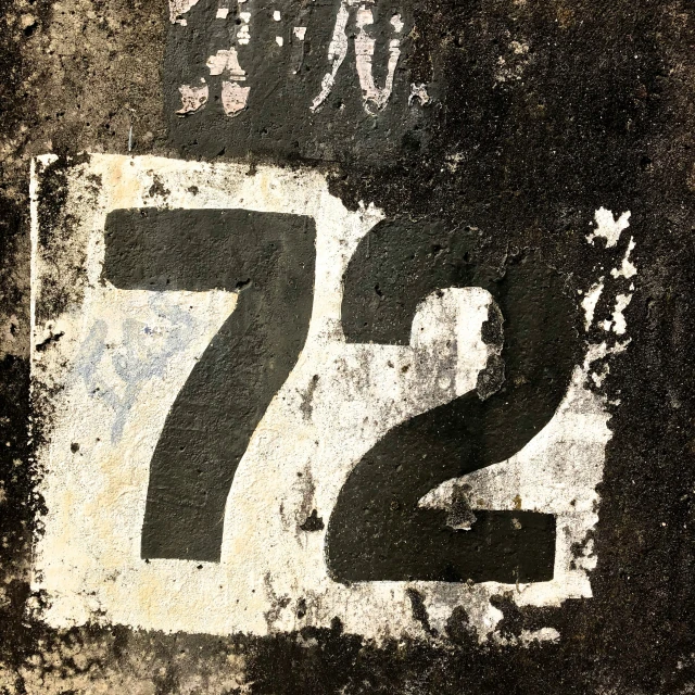 an old white and black sign with the number seven
