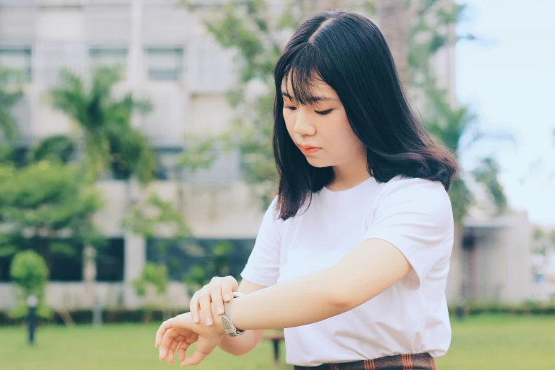 a woman standing in a park with her hands together