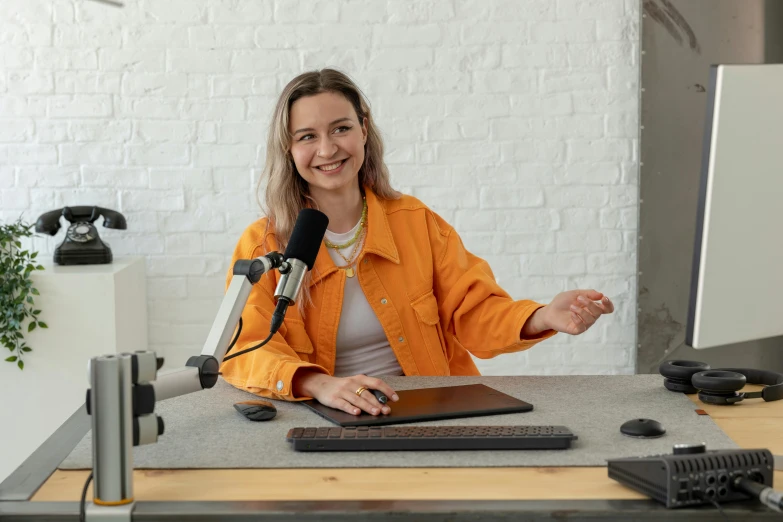 a person standing in front of a microphone and laptop computer