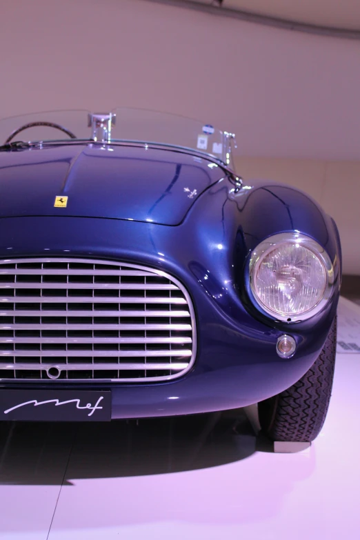 a blue car with a silver hood is on display