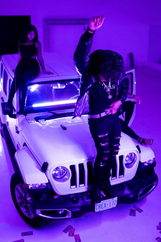 two people standing on a jeep in a purple room