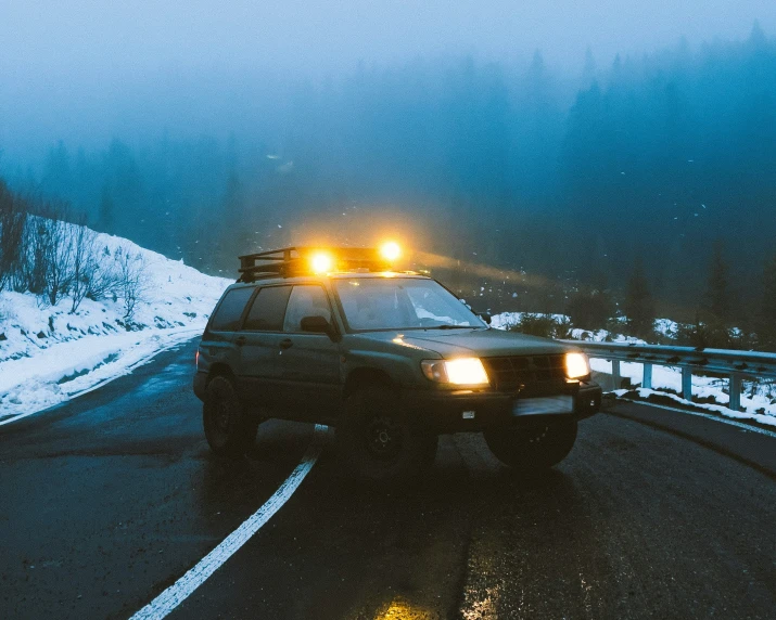 an ambulance drives in a snowy, dreary night