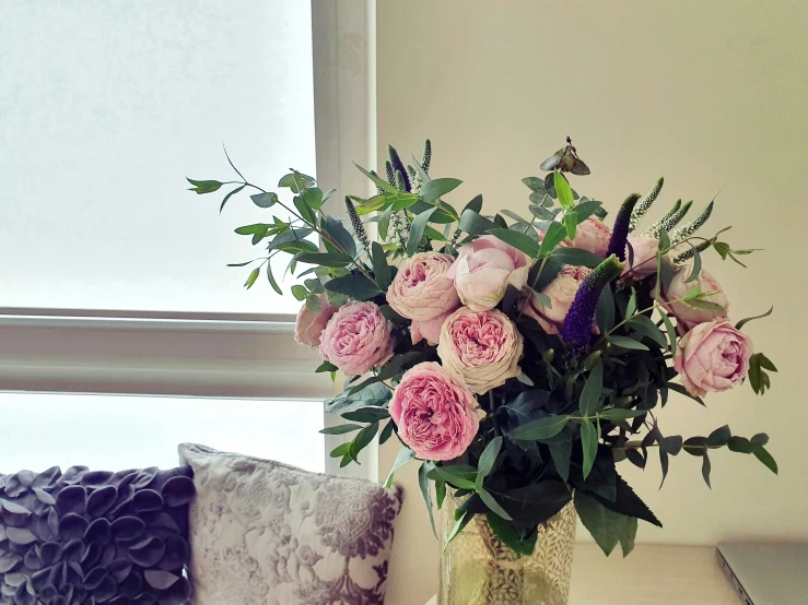 a vase with pink and purple flowers on a table