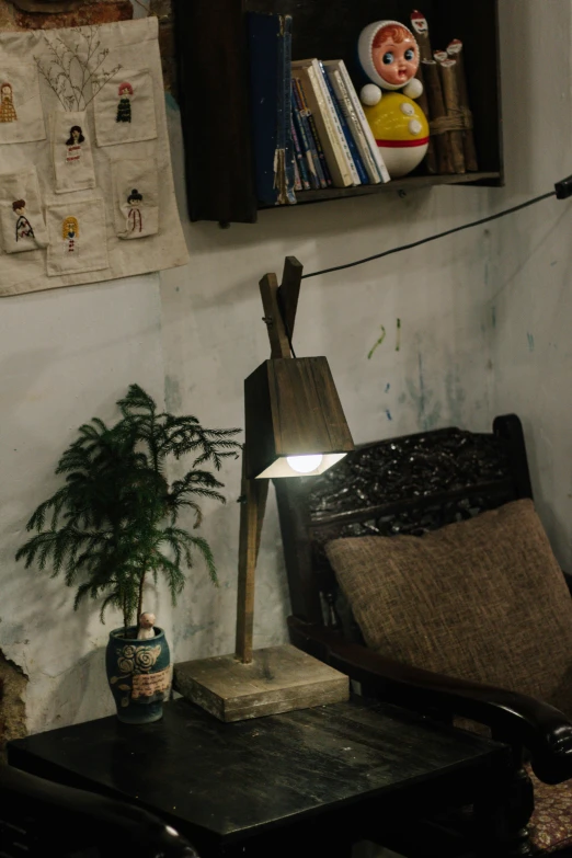 a small lamp next to a chair and table with books