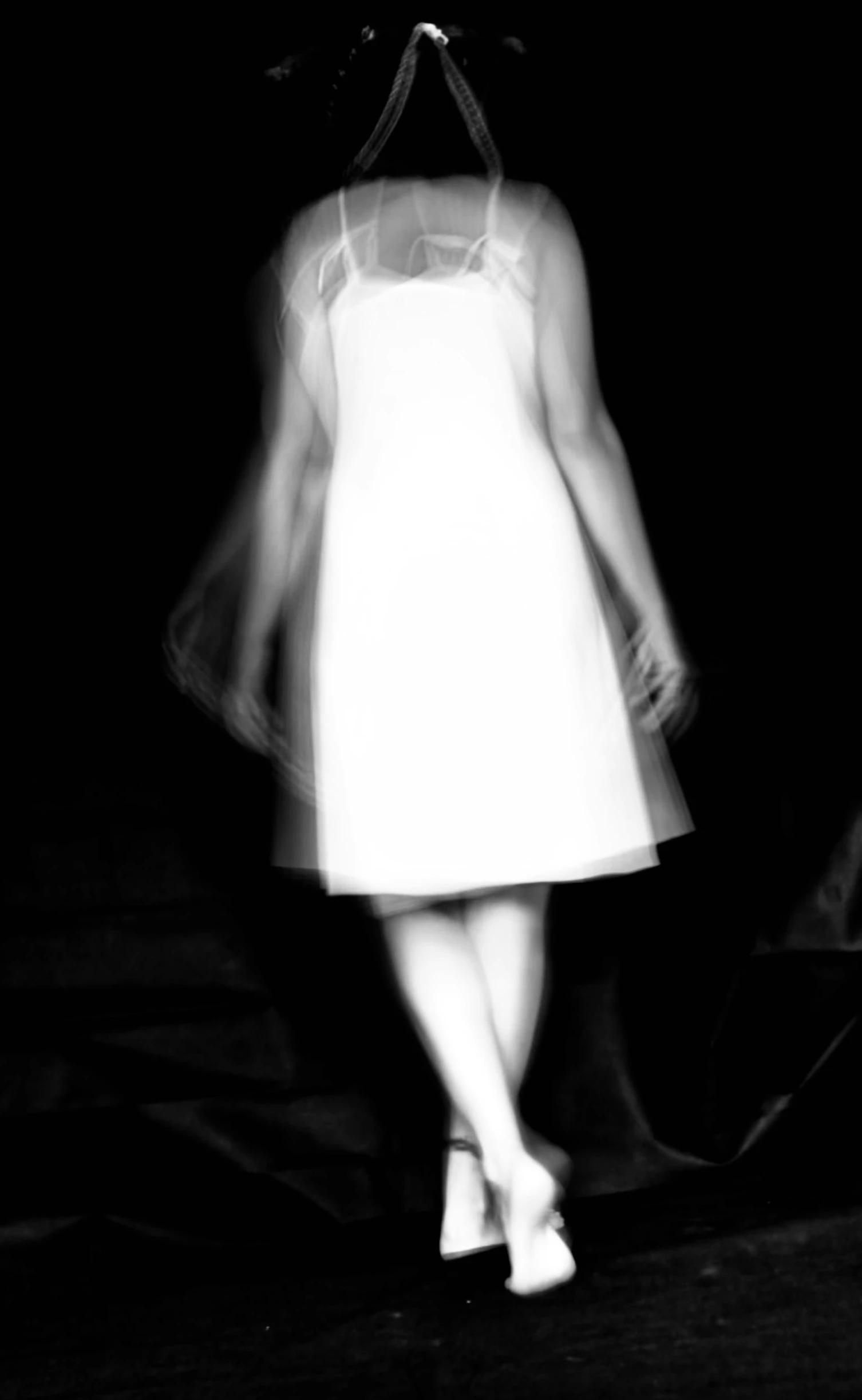a black and white po of a woman standing in the dark