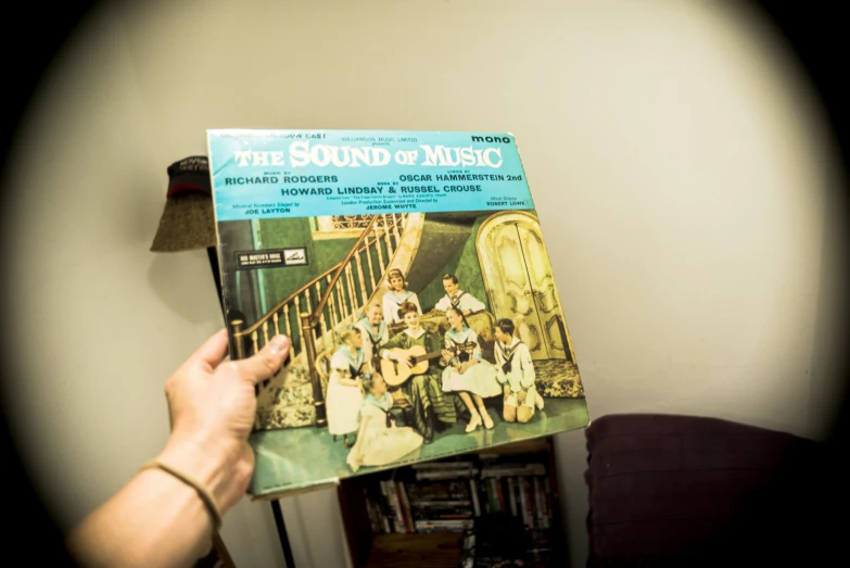 a person holding a magazine in front of a table