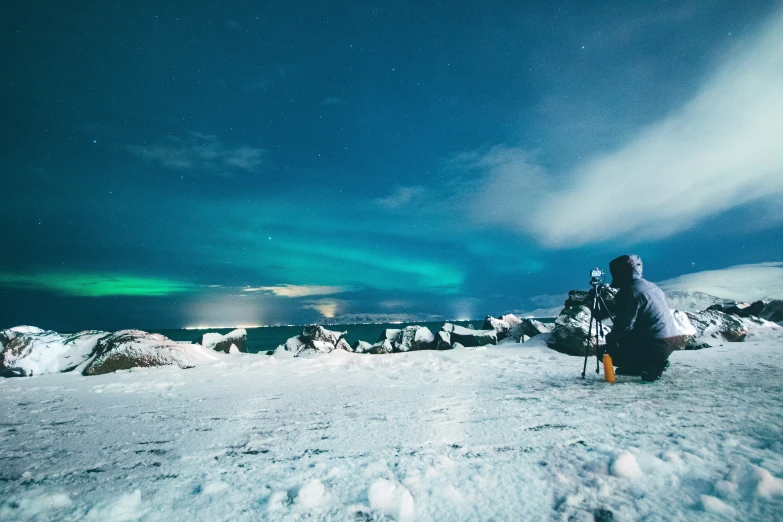 snow skier walking on the mountain with an aurora bore in the sky