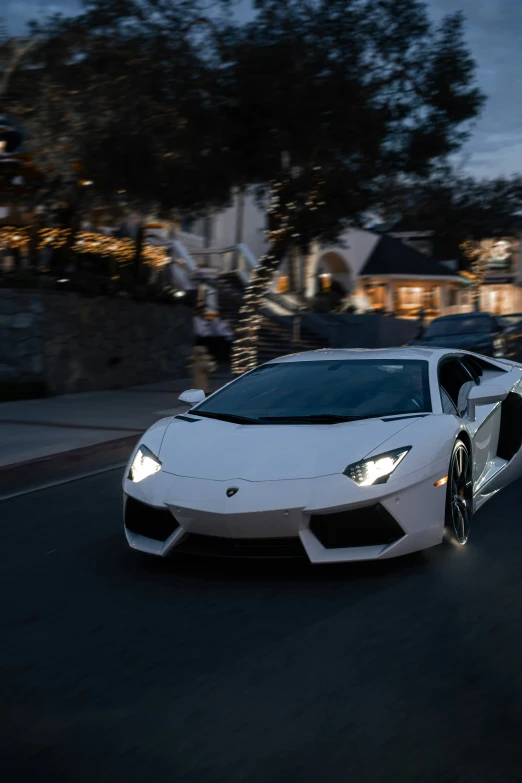 a white sports car driving down the road at night
