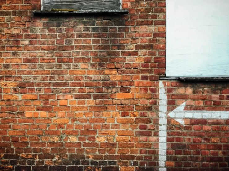 the street sign is on a brick wall