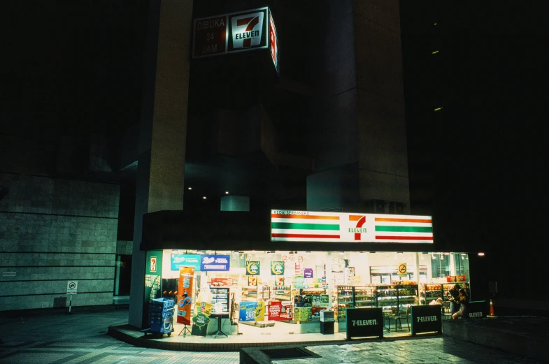 a store in the dark with two flags hanging over the windows