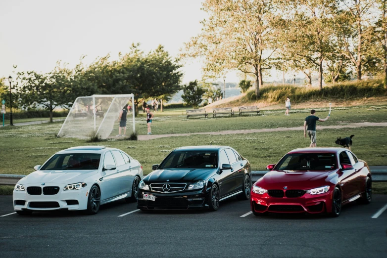 four different colored cars parked in a parking lot