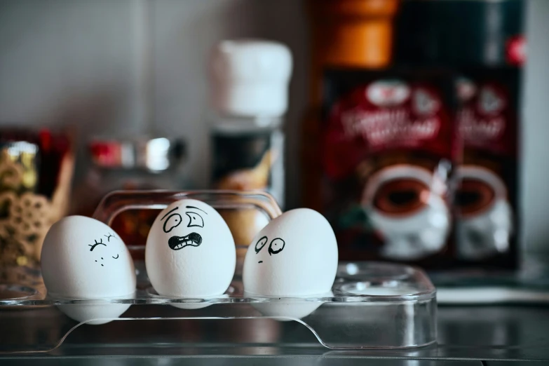 three white eggs with black ink drawn on them